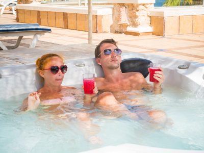 Smiling loving couple relaxing together on a jacuzzi pool at tourist resort